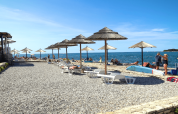 Spiaggia con ombrelloni e lettini al Camping Zelena Laguna, un villaggio vacanze in Istria, Croazia.
