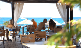 Personas comiendo con vista al mar en Camping Zelena Laguna, parque vacacional en Istria, Croacia.