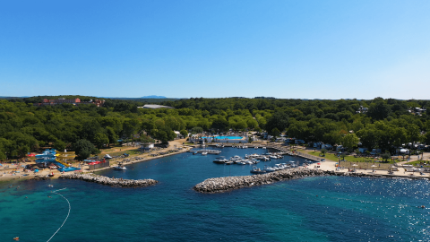 Camping Zelena Laguna in Istria, Croazia con porto turistico, spiaggia, scivoli d'acqua e natura verdeggiante.