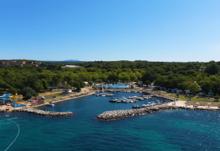 Camping Zelena Laguna in Istria, Croazia con porto turistico, spiaggia, scivoli d'acqua e natura verdeggiante.