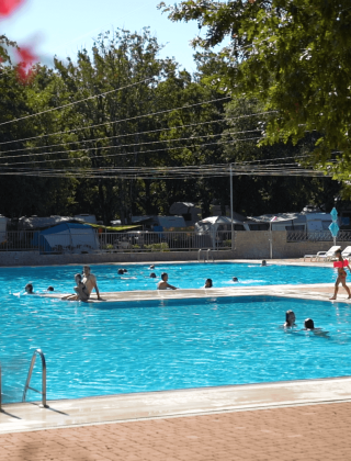 Piscina al aire libre con visitantes nadando y descansando en Camping Bijela Uvala, parque vacacional en Istria, Croacia.