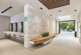 Modern and bright restroom and sink facilities with seating at Camping Bijela Uvala in Istria, Croatia.