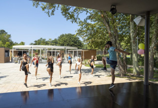 Gruppe fitnessklasse udendørs på Camping Bijela Uvala, feriested i Istrien, Kroatien, på en solrig dag.