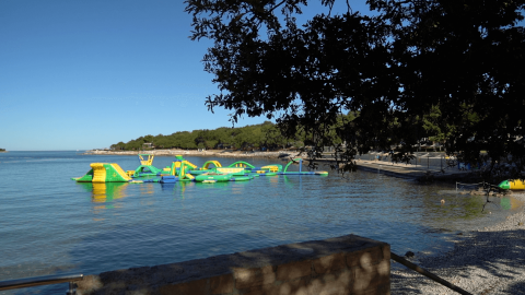 Blick auf das Meer und einen aufblasbaren Wasserpark im Camping Bijela Uvala in Istrien, Kroatien.