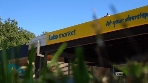 Foto del Lito Market presso Camping Bijela Uvala, Istria, Croazia, con insegna gialla e blu del negozio.