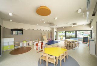 Bright and modern children’s playroom at Camping Bijela Uvala holiday park in Istria, Croatia with colorful tables.