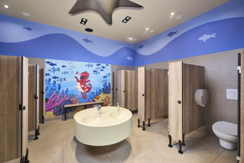 Child-friendly bathroom at Camping Bijela Uvala with underwater mural and stalls in Istria, Croatia.