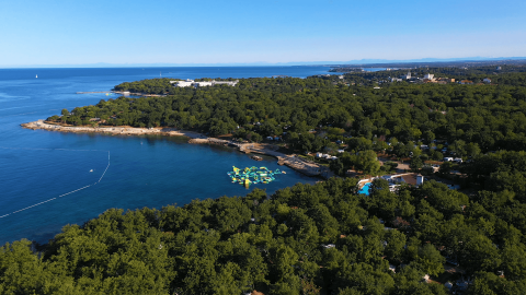 Vista aerea del Camping Bijela Uvala con foresta verde, costa e mare blu a Istria, Croazia.