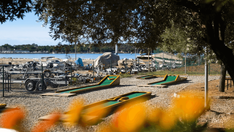 Campo de minigolf en Camping Bijela Uvala con vista al agua y barcos guardados en Istria, Croacia.