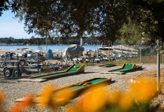 Campo da minigolf al Camping Bijela Uvala con vista sull’acqua e barche ormeggiate in Istria, Croazia.