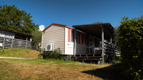 Casa móvil con porche de madera en Camping Bijela Uvala, parque vacacional en Istria, Croacia, día soleado.