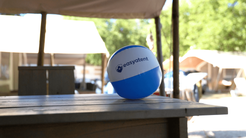 Blauer und weißer Easyatent-Strandball auf einem Holztisch auf dem Campingplatz Bijela Uvala in Istrien, Kroatien.