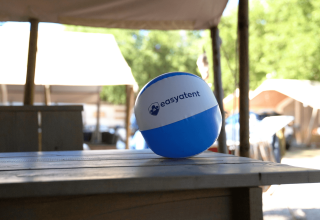 Blauer und weißer Easyatent-Strandball auf einem Holztisch auf dem Campingplatz Bijela Uvala in Istrien, Kroatien.