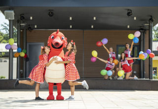 Børn i farverige kostumer og en maskot på scenen med balloner ved Camping Bijela Uvala, Istrien, Kroatien.