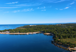 Vista aérea de Camping Bijela Uvala en Istria, Croacia, mostrando la costa boscosa y el mar azul.