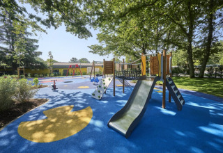 Playground with slide and climbing frame in a shaded area at Camping Bijela Uvala in Istria, Croatia.
