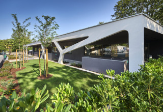 Modern building with garden at Camping Bijela Uvala holiday park in Istria, Croatia, on a sunny day.
