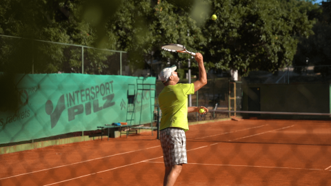 Un uomo gioca a tennis su un campo all'aperto al Camping Bijela Uvala, parco vacanze in Istria, Croazia.