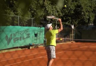 En mand spiller tennis på en udendørs bane ved Camping Bijela Uvala feriested i Istrien, Kroatien.
