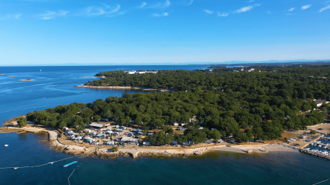Vista aerea del Camping Bijela Uvala in Istria, Croazia, con piazzole tra la costa e zone alberate.