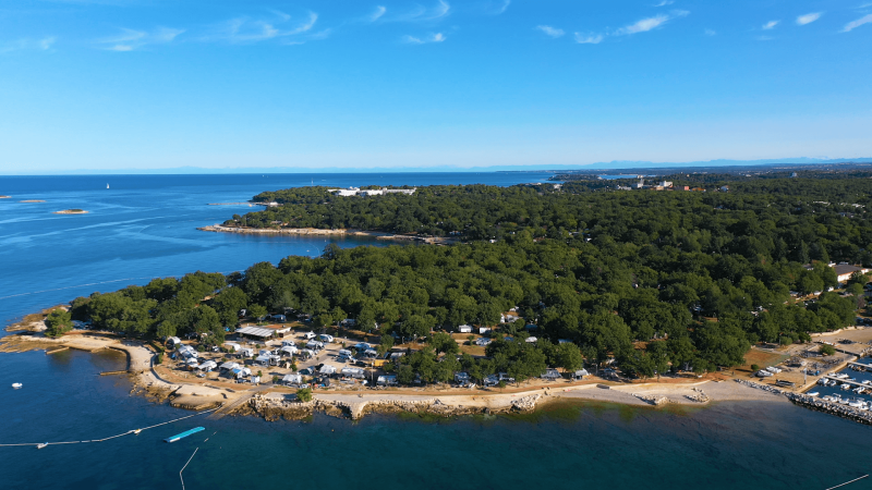 Vue aérienne du Camping Bijela Uvala en Istrie, Croatie, montrant le littoral et des zones boisées.