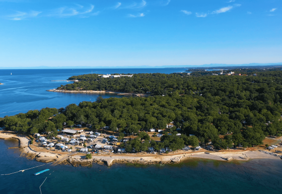 Aerial view of Camping Bijela Uvala holiday park in Istria, Croatia, showing coastline and forest areas.