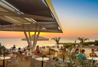 Udendørs restaurant ved Camping Aminess Maravea i Istrien, Kroatien, med havudsigt ved solnedgang.
