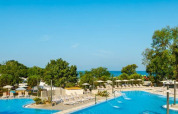 Feriepark ved pool i Camping Aminess Maravea, Istrien, Kroatien, med liggestole, træer og havudsigt.