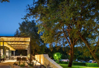 Udendørs restaurant og grønne omgivelser i Camping Aminess Maravea feriepark, Istrien, Kroatien ved skumring.