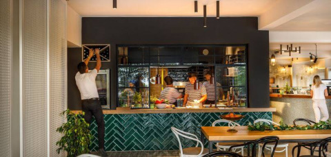 Interior de restaurante moderno en Camping Aminess Maravea, Istria, Croacia, con clientes y personal presentes.