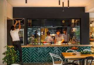 Interior de restaurante moderno en Camping Aminess Maravea, Istria, Croacia, con clientes y personal presentes.