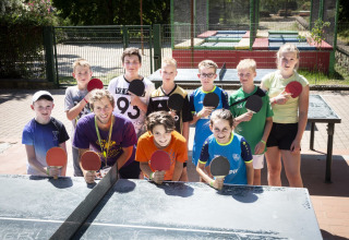 Niños y jóvenes posan con palas de tenis de mesa en hu Birkelt Village, parque vacacional en Mersch, Luxemburgo.