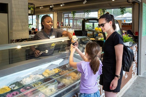 Une femme et une enfant reçoivent une glace d'une vendeuse chez hu Birkelt Village à Mersch, Luxembourg.