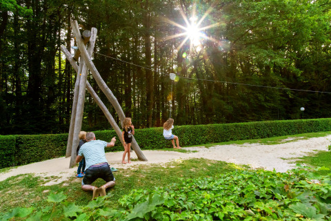 Børn leger og svinger på en zipline i en solrig park ved hu Birkelt Village i Mersch, Luxembourg.