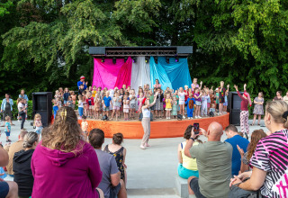 Kinderen en volwassenen genieten van een optreden in een vakantiepark in Mersch, Luxemburg.