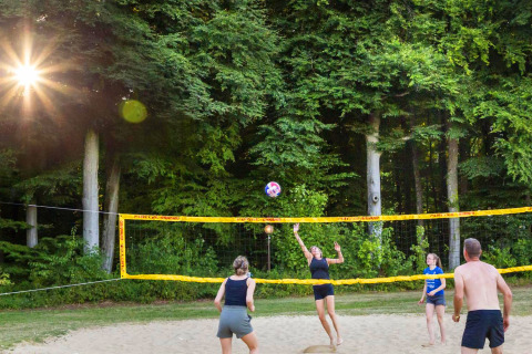 Folk spiller volleyball på en sandbane i skoven ved hu Birkelt Village feriepark i Mersch, Luxembourg.