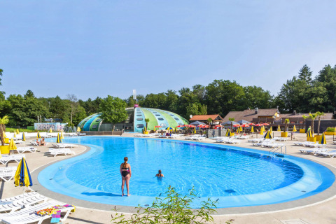 Outdoor swimming pool with sun loungers and colorful umbrellas at hu Birkelt Village in Mersch, Luxembourg.