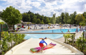 Niño en tobogán acuático con flotador en una piscina al aire libre en hu Birkelt Village, Luxemburgo.