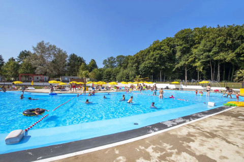 Piscina del parque vacacional hu Birkelt Village en Mersch, Luxemburgo, con huéspedes y sombrillas amarillas.