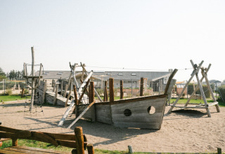 Parco giochi con nave di legno e strutture da arrampicata al Løkken Klit Camping, Jutland Settentrionale, Danimarca.