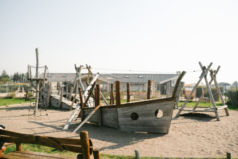 Aire de jeux avec un bateau en bois et des structures d’escalade à Løkken Klit Camping, Jutland du Nord, Danemark.