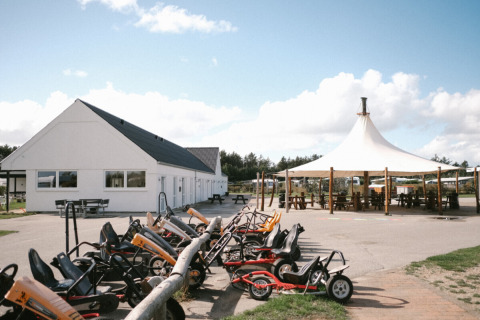 Løkken Klit Camping in Jutland settentrionale, Danimarca, con go-kart a pedali, edificio bianco e tenda.