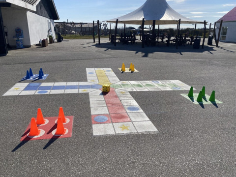 Gioco da tavolo all'aperto con coni e dado sull'asfalto a Løkken Klit Camping, Jutland Settentrionale, Danimarca.