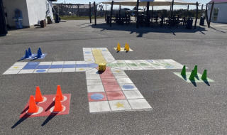 Outdoor-Brettspiel mit Kegeln und Würfel auf Asphalt im Løkken Klit Camping, Nordjütland, Dänemark.