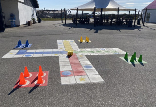 Buitenspel met kegels en een dobbelsteen op het asfalt bij Løkken Klit Camping, Noord-Jutland, Denemarken.