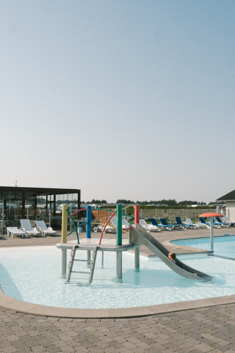 Zona de piscina infantil con tobogán y juegos en Løkken Klit Camping, Jutlandia del Norte, Dinamarca.