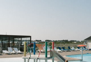 Børnevenligt poolområde med rutsjebane og legeredskaber på Løkken Klit Camping i Nordjylland, Danmark.