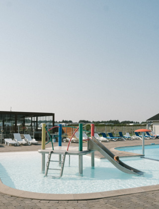 Kinderfreundlicher Pool mit Rutsche und Spielgeräten im Løkken Klit Camping in Nordjütland, Dänemark.