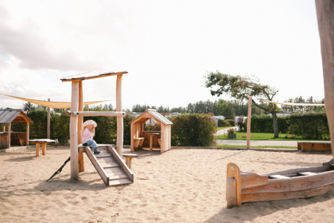 Parco giochi in legno con sabbia e casette al Løkken Klit Camping in Jutland Settentrionale, Danimarca.