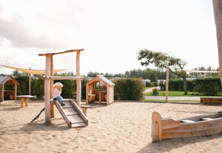 Parco giochi in legno con sabbia e casette al Løkken Klit Camping in Jutland Settentrionale, Danimarca.